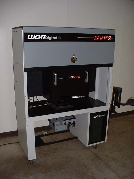 DVP2 in customer-lab deployment — the same LUCHTdigital cabinet installed on the photo-lab floor with the upper canister door open, ready for paper load. The fully-upgradeable platform was sold to professional labs alongside the existing VP-2 fleet, with the patent-pending digital exposure system as the next-generation upgrade path.